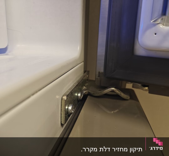תמונה של דלת מקרר פתוחה עם ציר מתכת